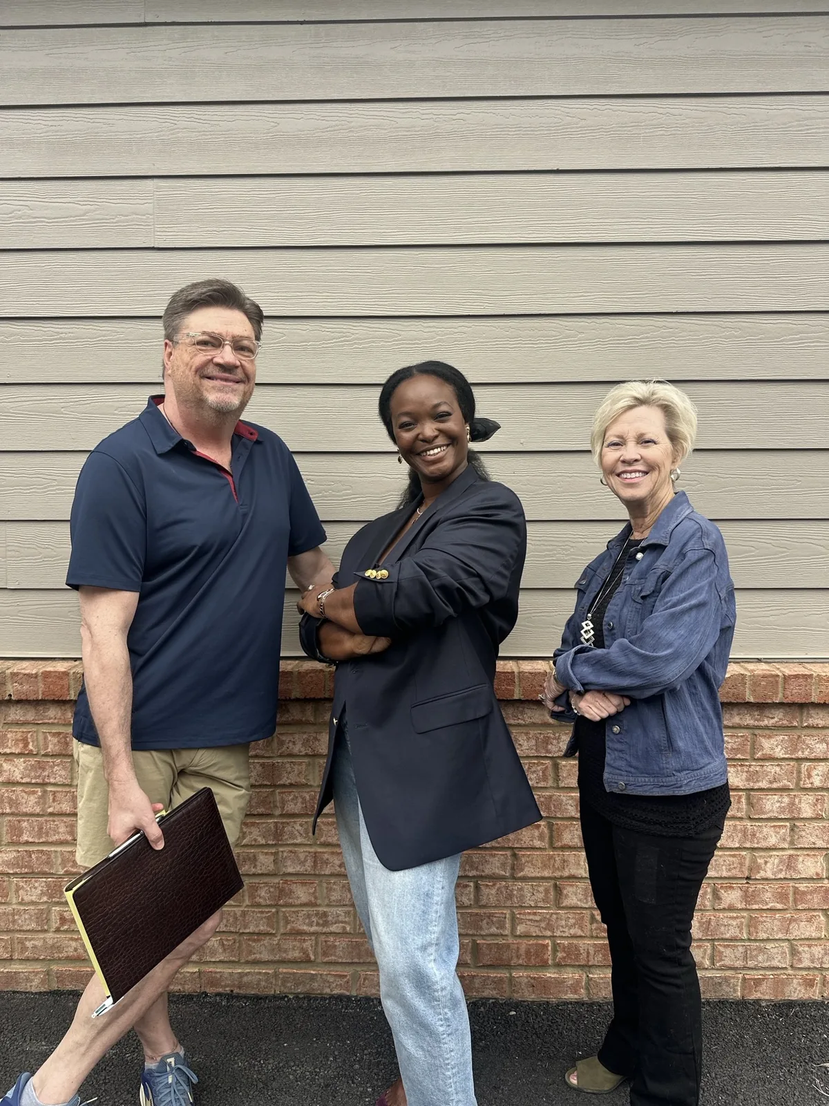 The Welcome Home team — Robin Alexander, Osaze Omokaro and Susan Levy — standing together outside a client's home